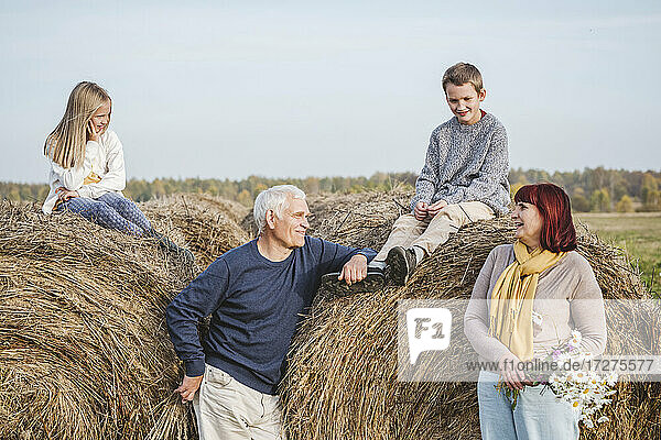 Großeltern mit Enkelkindern auf Heuballen sitzend