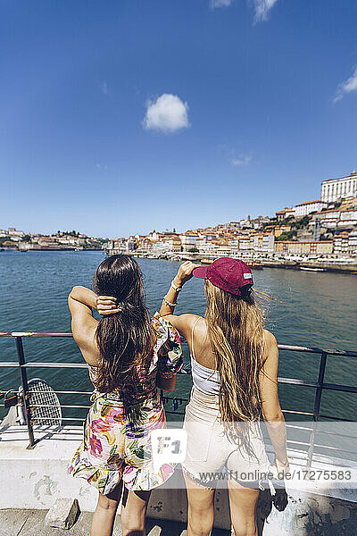 Female friends looking at Douro River while spending weekend together in city  Porto  Portugal