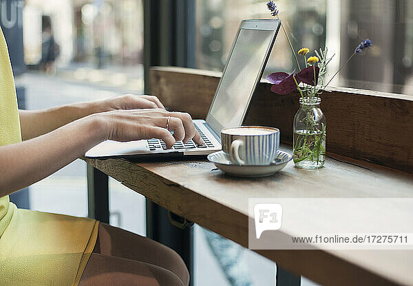 Junge Geschäftsfrau arbeitet an einem Laptop in einem Café
