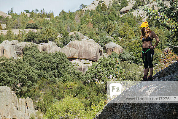 Female trekker admiring view while standing on rock in forest at La Pedriza  Madrid  Spain