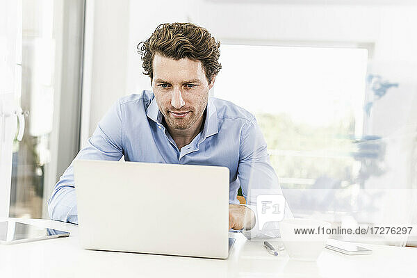 Mittlerer erwachsener Mann arbeitet am Laptop im Büro