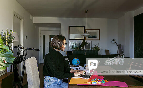 Geschäftsfrau  die konzentriert am Laptop arbeitet  während sie zu Hause sitzt