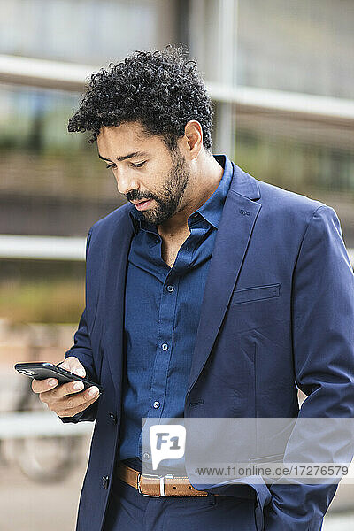 Entrepreneur using mobile phone while standing in city