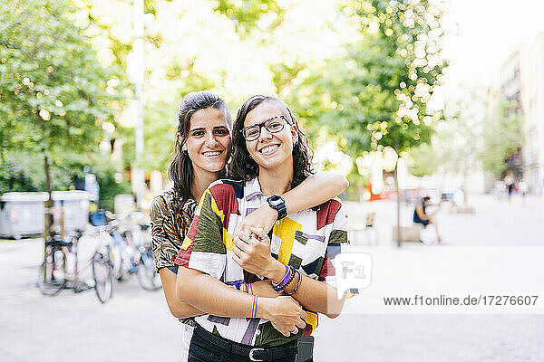 Hipster-Paar umarmt sich gegenseitig  während auf der Straße in der Stadt stehen