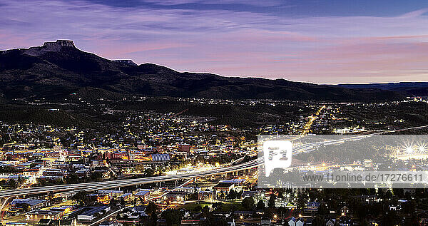 USA  Colorado  Trinidad  Interstate 25  die sich nachts durch die beleuchtete Stadt zieht  mit Fishers Peak im Hintergrund