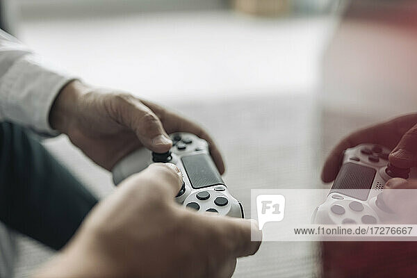 Businessman hands holding video game remote control at office