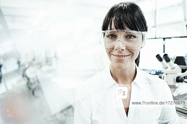 Lächelnde Technikerin mit Schutzbrille in der Industrie