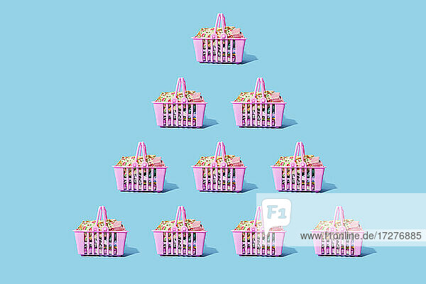 Studio shot of pink shopping baskets arranged in triangle