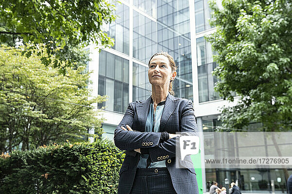 Businesswoman with arms crossed standing at office park