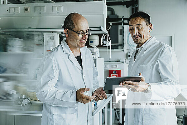 Scientist using digital tablet while standing at laboratory
