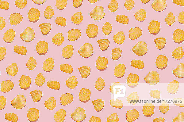 Potato chips on pink background