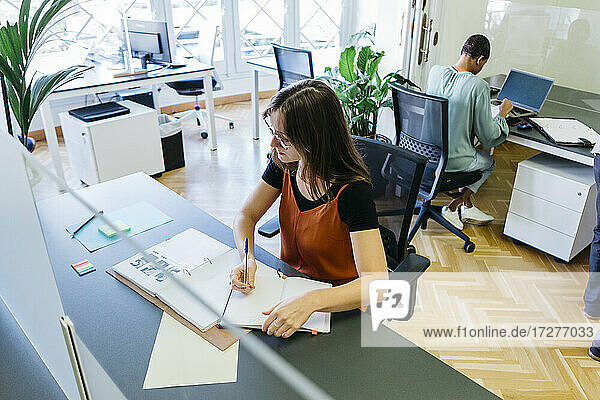 Hohe Winkel Ansicht der weiblichen Unternehmer schreiben in Tagebuch im Büro Schreibtisch