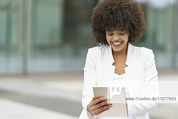 Smiling businesswoman using digital tablet outdoors
