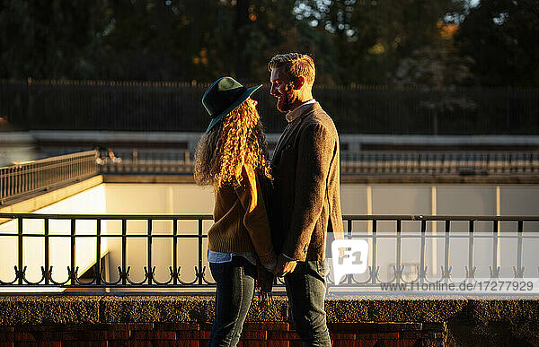 Verheiratetes Paar  das sich gegenseitig ansieht  während es an einem Geländer in der Stadt steht