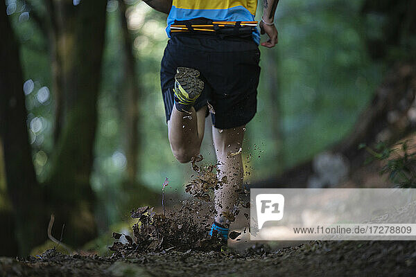 Trailrunner running with speed on mountain trail at forest