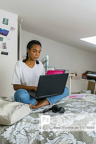Teenage girl using laptop while sitting at home