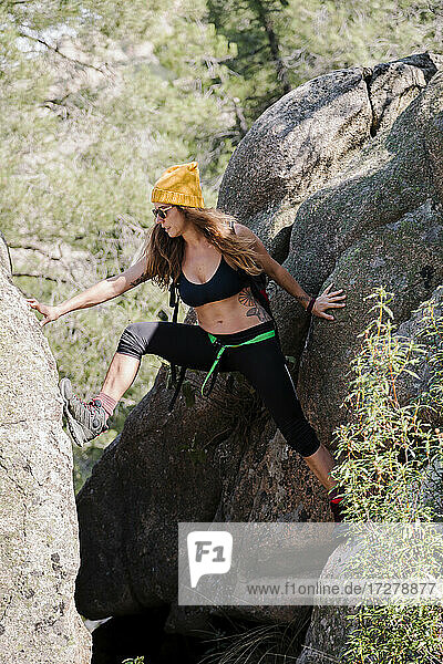 Frau klettert auf einem Felsen im Wald bei La Pedriza  Madrid  Spanien