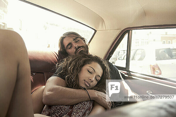 Junges Paar schläft im Auto an einem sonnigen Tag