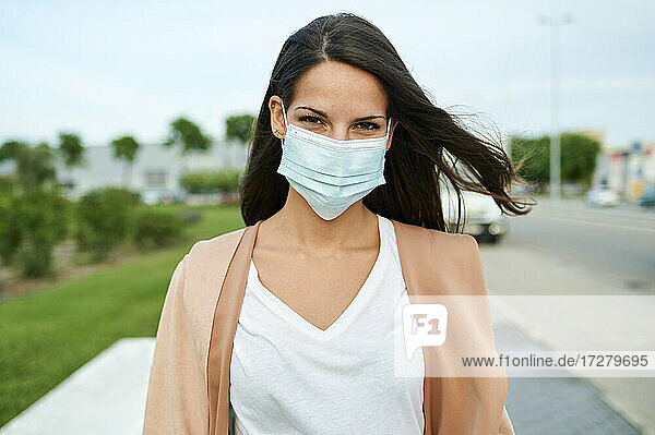 Junge Frau mit Gesichtsschutzmaske auf der Straße