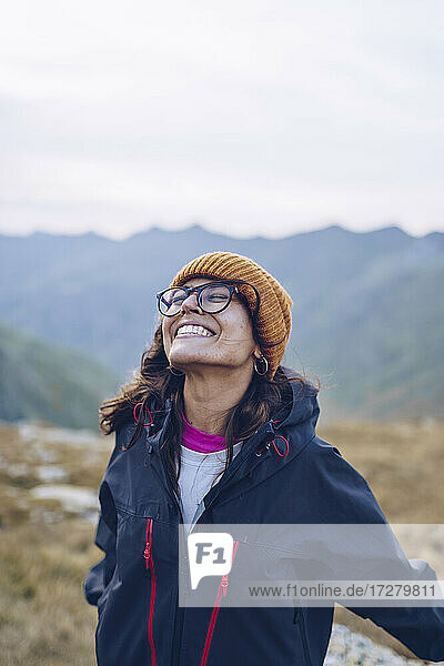 Unbekümmerte Frau mit geschlossenen Augen  die lächelnd auf einem Berg in der Nähe von Ibones of Anayet steht