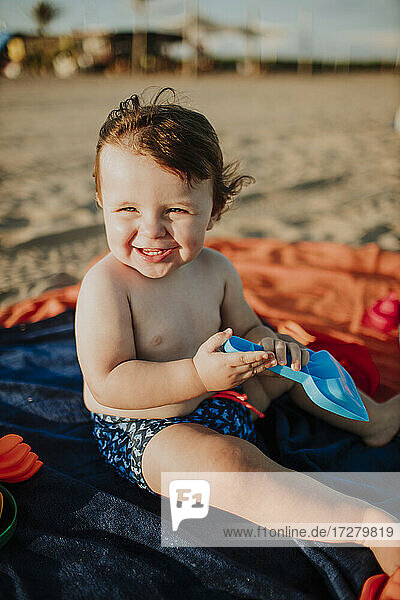 Männliches Kleinkind genießt das Spielen an einem sonnigen Tag am Strand