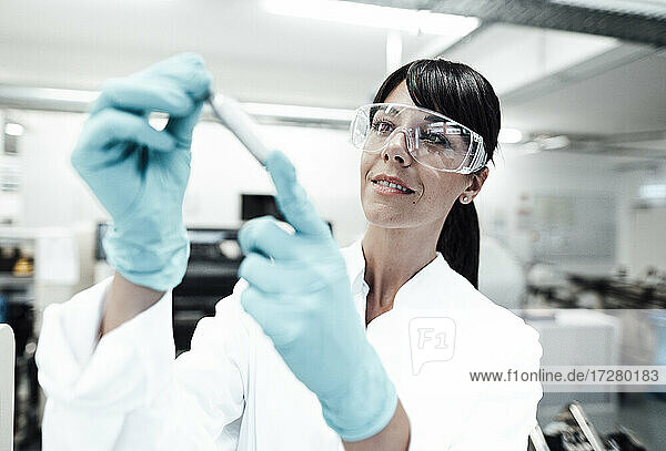 Lächelnde reife Wissenschaftlerin betrachtet eine Probe im Labor