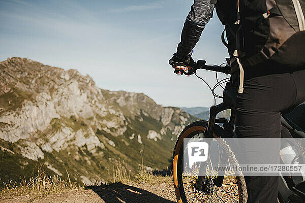 Mountainbikerin auf einem Elektrofahrrad vor einem Berg im Naturpark Somiedo  Spanien