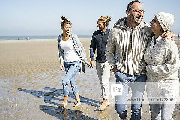 Young and mature couple walking together at beach