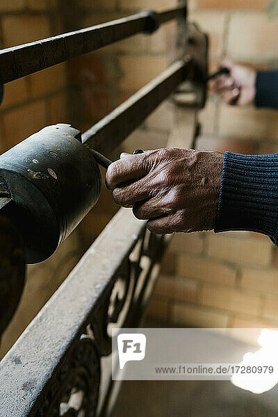 Hands of worker weighing grapes on old-fashioned scale at winery