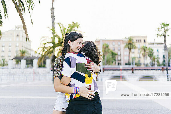 Glückliches lesbisches Paar umarmt sich auf der Straße