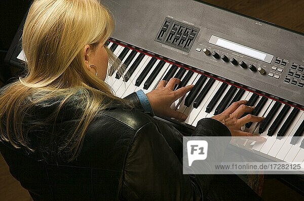 Musikerin singt  während sie Digitalpiano spielt
