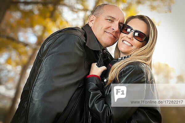 Happy  attractive couple in park with leather jackets