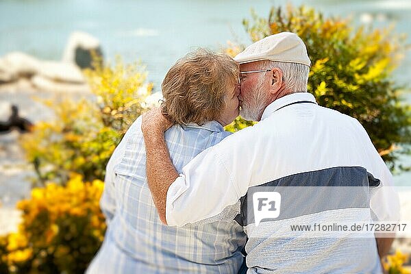 Happy senior couple kissing each other in the park