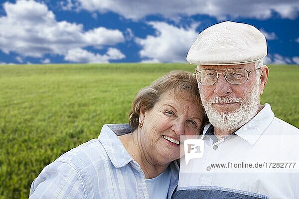 Happy loving senior couple standing in grass field