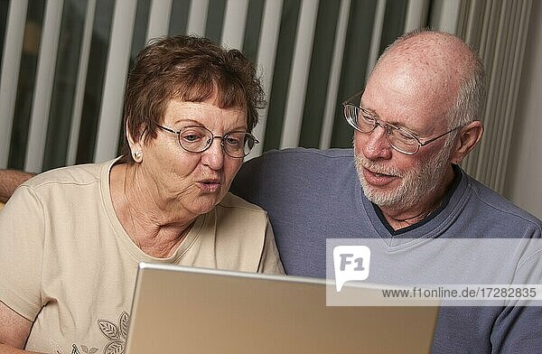 Lächelnde ältere erwachsene Paar Spaß auf dem Computer Laptop zusammen haben