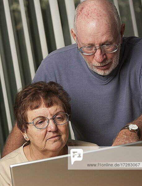Lächelnde ältere erwachsene Paar Spaß auf dem Computer Laptop zusammen haben