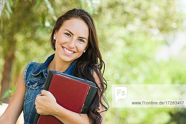 Attraktive lächelnde gemischtrassige junge Mädchen Studentin mit Schule Bücher im Freien
