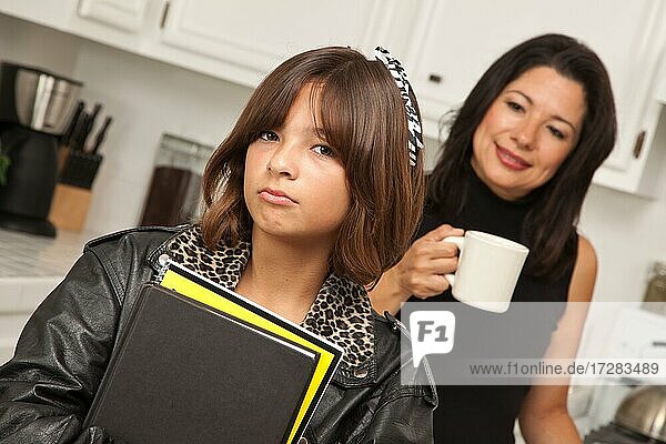 Hübsches hispanisches Mädchen und Mutter immer bereit für die Schule in der Küche