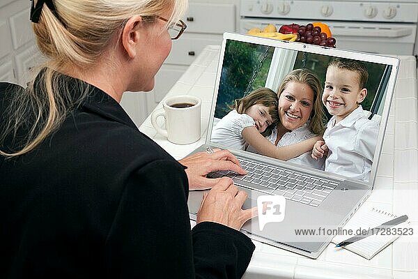 Frau in der Küche mit Laptop sehen Freunde und Familie. Bildschirm kann leicht für Ihre eigene Nachricht oder Bild verwendet werden