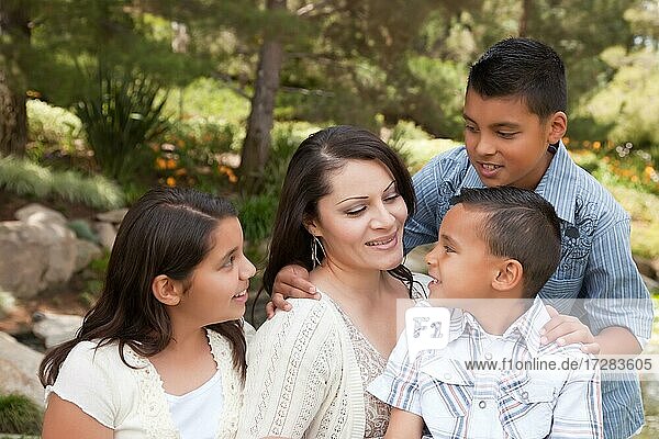 Glückliche hispanische Mutter und Kinder im Park