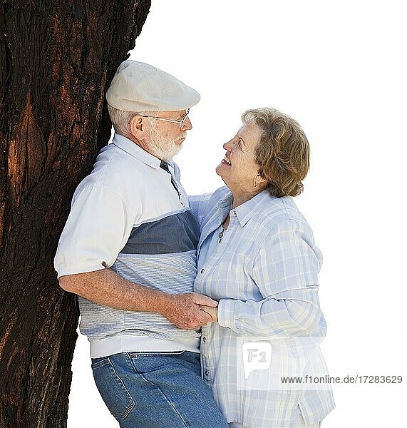 Affectionate loving senior couple leaning against tree isolated on white