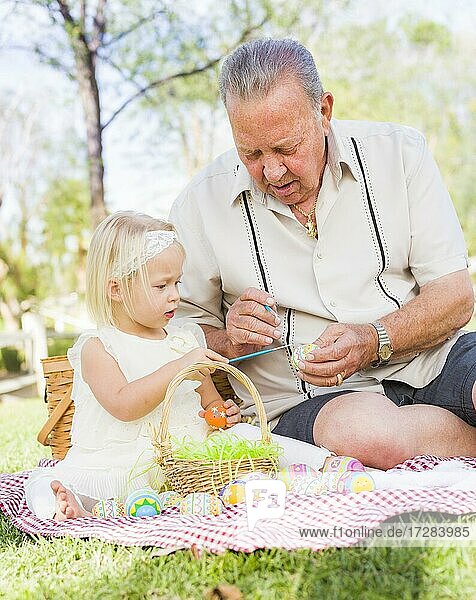 Liebevolle Großvater und Enkelin Färbung Ostereier zusammen auf Picknick-Decke im Park