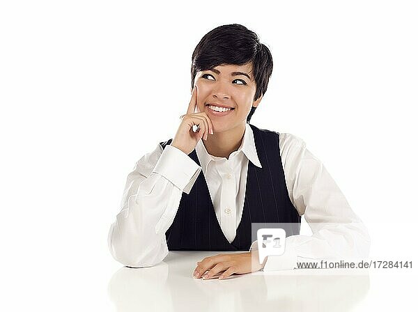 Attractive smiling mixed-race young adult female at white table looking up and away isolated on a white background