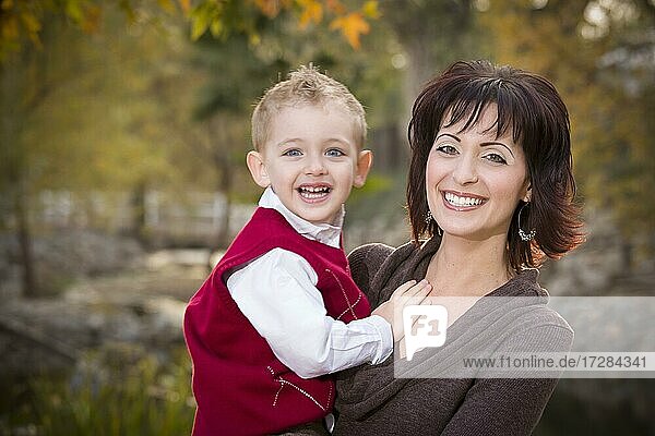 Attractive mother and cute son portrait outside at the park