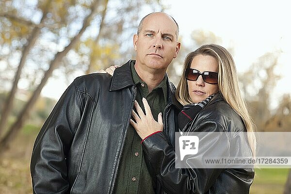 Serious attractive couple in park with leather jackets