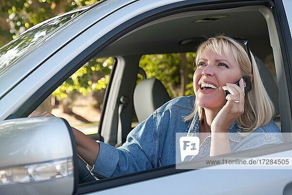Attraktive blonde Frau mit Handy während der Fahrt