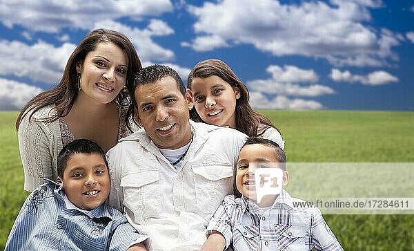 Glückliche hispanische Familie Porträt sitzen in Wiese