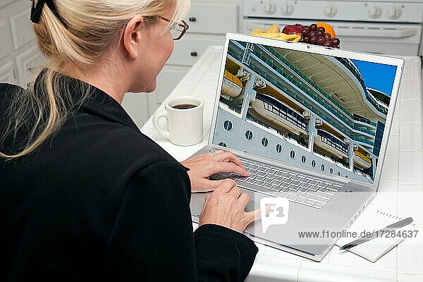 Frau in der Küche mit Laptop zu recherchieren  Reisen  Urlaub und Kreuzfahrten. Bildschirm kann leicht für Ihre eigene Nachricht oder Bild verwendet werden