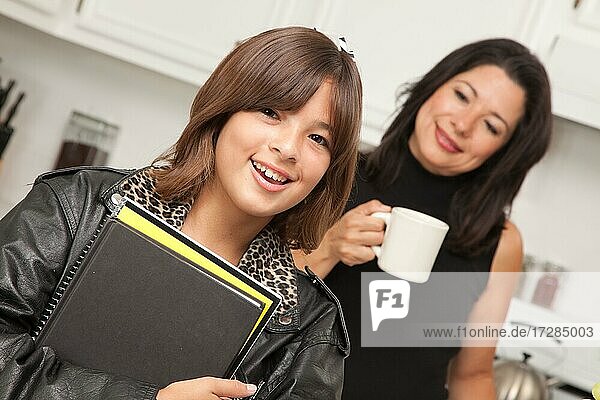 Hübsches hispanisches Mädchen bereit für die Schule mit Mama im Hintergrund