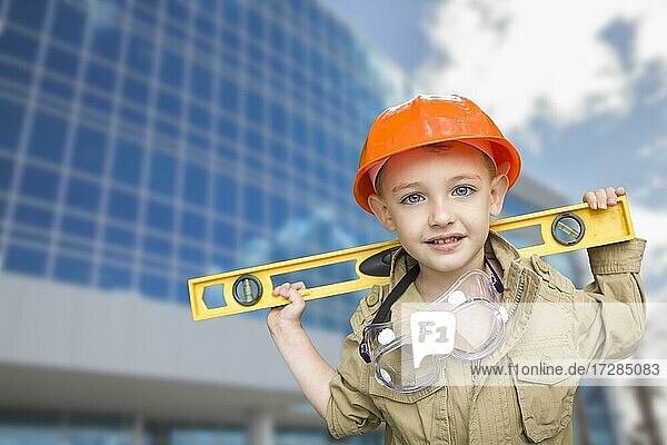 Adorable Kind Junge gekleidet wie ein Handwerker vor Firmengebäude